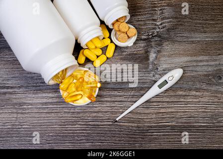 Top view mockup bottiglia per pillole e vitamine su sfondo nero, naturale bio supplemento biologico Pillole mediche in vaso bianco su un isolato ba di legno Foto Stock