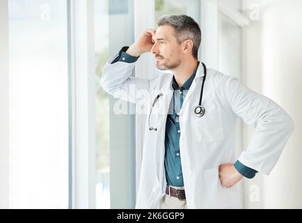 Facciamo una vita da ciò che otteniamo. un medico maschio che ha una giornata stressante sul lavoro. Foto Stock