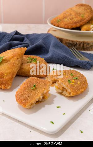 Polpettine di carne e foglie di prezzemolo su piatti di ceramica bianca in una cucina da banco. Foto Stock