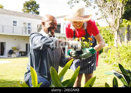 Felice coppia anziana diversa che lavora in giardino Foto Stock