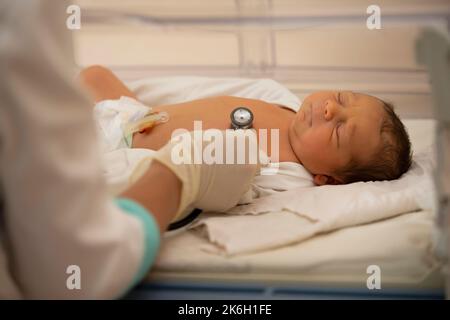 Neonatologia. Medico che ascolta il battito cardiaco di un neonato in un incubatore infantile Foto Stock