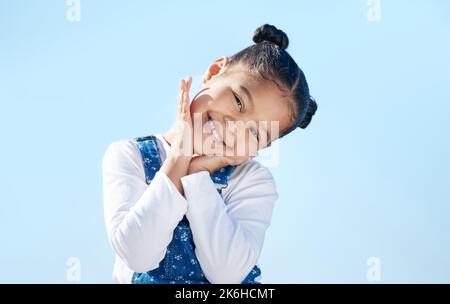 Non mi piacciono le foto. una bambina che guarda timida mentre sta in piedi fuori. Foto Stock