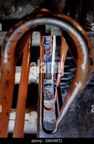 Vista della vecchia scala arrugginita arancione dipinta ringhiera in ferro nel parcheggio del vecchio edificio. Corrimano in vecchio metallo, messa a fuoco selettiva. Foto Stock