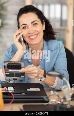 una giovane ingegnere femminile è focalizzata sulla riparazione del laptop Foto Stock