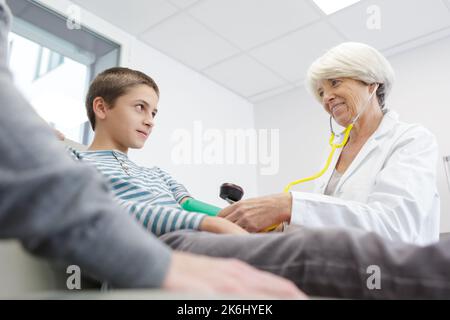 medico senior femminile con bambino in ufficio Foto Stock