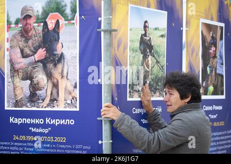 Kiev, Ucraina. 14th Ott 2022. Una donna reagisce emotivamente alla mostra di strada 'Azov Regiment - Angels of Mariupol', dedicata ai difensori dell'unità 'Azov' della Guardia Nazionale Ucraina, che morì difendendo Mariupol dagli invasori russi a Kyiv. Le truppe russe sono entrate in Ucraina il 24 febbraio 2022 iniziando un conflitto che ha provocato distruzione e crisi umanitaria. (Foto di Oleksii Chumachenko/SOPA Images/Sipa USA) Credit: Sipa USA/Alamy Live News Foto Stock