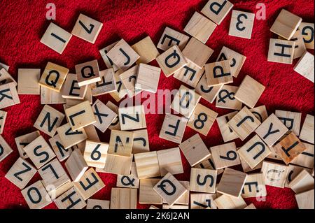 Lettere nere poste su legno. Piccoli pezzi di alfabeto. Foto Stock