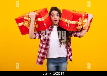 Faccia stupita scioccata, emozioni stupite della giovane ragazza adolescente. Regalo emotivo bambino adolescente tenere il compleanno. Ragazza capretto divertente che tiene le scatole del regalo Foto Stock