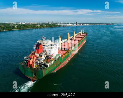 Vista aerea di una nave da carico completamente caricata che lascia il porto di Montreal e che scende lungo il fiume San Lorenzo. Foto Stock