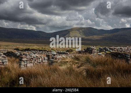 Vecchie rovine in un paesaggio impressionante delle vaste e remote terre di campagna ai margini del Wild Nephin National Park, Co. Mayo, Irlanda. Foto Stock