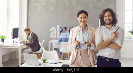 Banner con ritratto di due uomini d'affari sorridenti e felici in piedi sul posto di lavoro Foto Stock