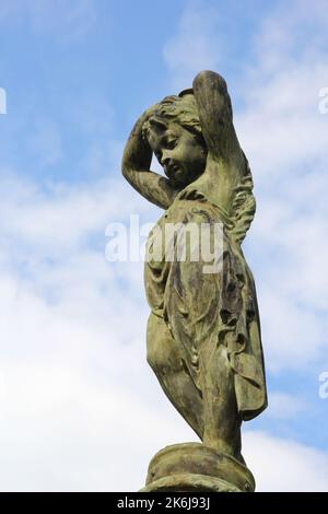 Piccolo angelo statua di bronzo contro cielo blu Foto Stock