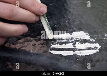 Pila di polvere medicinale pila e linee su un tavolo di vetro, primo piano. Concetto di dipendenza. Foto Stock