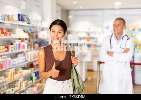 Ritratto di una donna cliente sorridente felice con il servizio in farmacia moderna Foto Stock