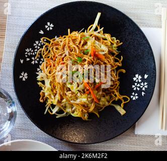 Tagliatelle in stile giapponese con verdure yakisoba splendidamente servite nella ciotola Foto Stock