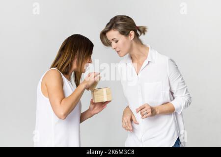 Giovane bella donna con sorriso dà un presente al suo amico. Buon compleanno Foto Stock