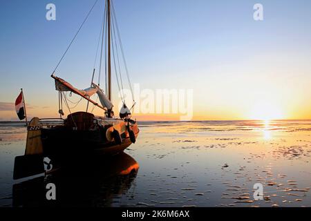 Una classica barca a vela adagiata sulle maree del Mare di Wadden, Olanda Foto Stock