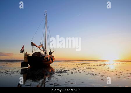Una classica barca a vela adagiata sulle maree del Mare di Wadden, Olanda Foto Stock