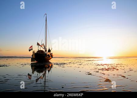 Una classica barca a vela adagiata sulle maree del Mare di Wadden, Olanda Foto Stock