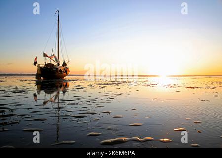 Una classica barca a vela adagiata sulle maree del Mare di Wadden, Olanda Foto Stock