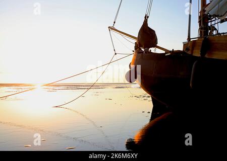 Una classica barca a vela adagiata sulle maree del Mare di Wadden, Olanda Foto Stock