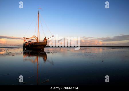 Una classica barca a vela adagiata sulle maree del Mare di Wadden, Olanda Foto Stock