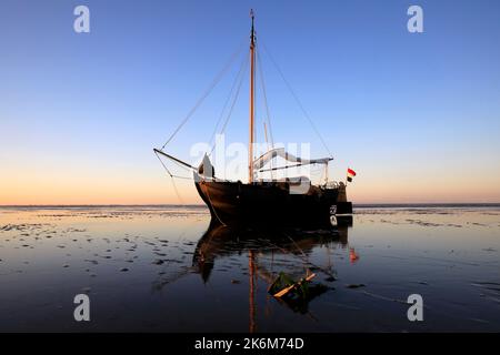 Una classica barca a vela adagiata sulle maree del Mare di Wadden, Olanda Foto Stock