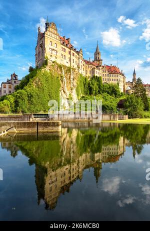 Il castello di Sigmaringen si trova sulla cima rocciosa del Danubio, Schwarzwald, Germania. Panoramica vista verticale del palazzo tedesco, cielo, acqua riflessione in estate. Tema Foto Stock