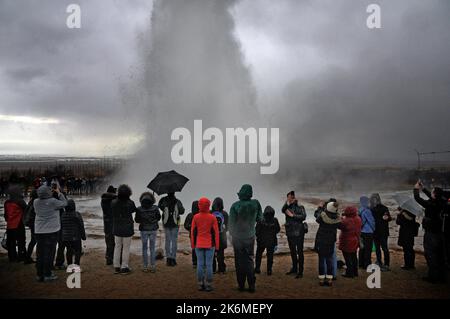 TURISTI A STROKKUR IL GEYSIR ATTIVO NELLA ZONA GEOTERMALE GEYSIR, HAUKADULAR VALLEY, ISLANDA 2018 PIC MIKE WALKER Foto Stock