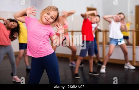 Ragazza che si esercita in gruppo durante la lezione di danza Foto Stock