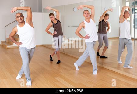 Giovani adulti che praticano movimenti di danza in classe coreografica Foto Stock