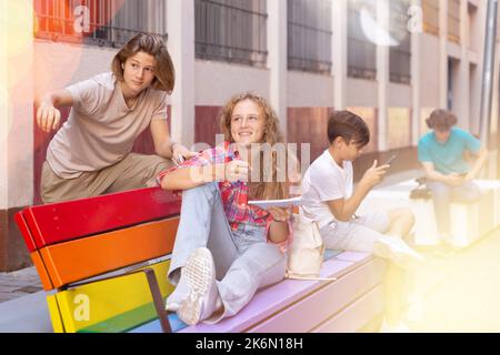 Il ragazzo e la ragazza hanno chiacchierata di divertimento. Guy punta la mano a qualcuno Foto Stock