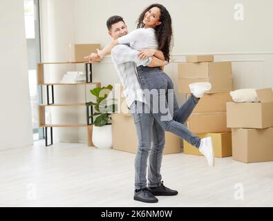 Erano ufficialmente proprietari di abitazione. una giovane coppia che si sposta nella loro nuova casa. Foto Stock