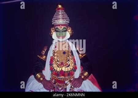 Kathakali:- la danza classica indiana del Kerala si basa su Ramayana, Mahabharata e Stories della letteratura Shaiva. Eseguite all'aperto in una funzione tutta la notte, le voci cantano le storie come imitato dai ballerini. Tradizionalmente Kathakali è eseguito da uomini e ragazzi, che giocano le parti di entrambi i maschi e femmine. I volti sono fatti per sembrare mascherine dipinte, i costumi sono costituiti da gonna piena, giacca pesante, numerosi ghirlande e headdress scollo e torreggiante. Foto Stock