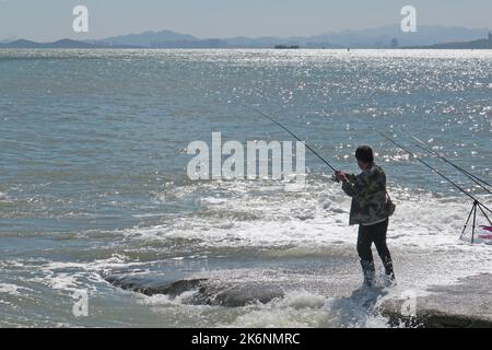 Gli appassionati di pesca marittima pescano al mare a Yantai, provincia di Shandong, Cina, 26 settembre 2022. Foto Stock