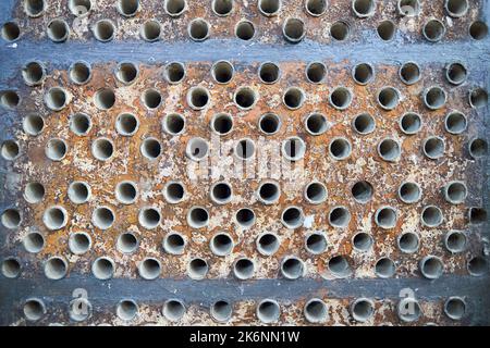 Piastra tubiera in lamiera di scambiatore di calore o di boiler closeup texture macro fondo industriale con insolubile depositi minerali duri saldatura a scala di sali Foto Stock