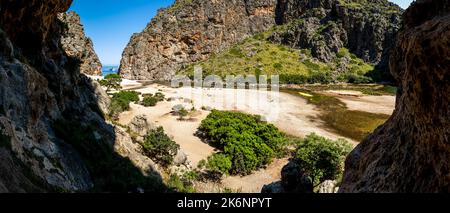 Ampia vista panoramica da una grotta alla spiaggia di ciottoli Cala de SA Calobra in estate nel canyon più profondo di Maiorca, nei monti Serra de Tramuntana. Foto Stock