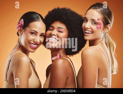 Bellezza, diversità e sorriso con donne e fiori per il trucco, cosmetici e benessere. Tropicale, naturale e di lusso con modello su sfondo marrone per Foto Stock