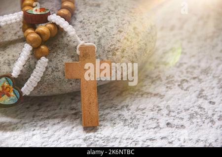 Santo Rosario in cima alla pietra con luce brillante. Concetto spirituale e Cristianesimo. Foto Stock