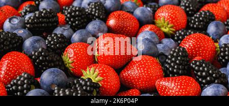 Sfondo di frutta fresca e frutti di bosco. Fragole mature, mirtilli e more . Mescolare le bacche e la frutta. Foto Stock