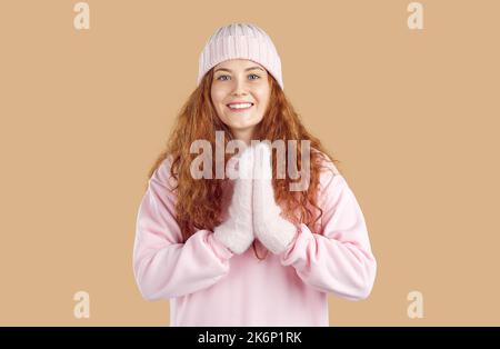 Ritratto di donna gioiosa che le batte le mani con gioia in inverno in previsione di qualcosa di piacevole Foto Stock