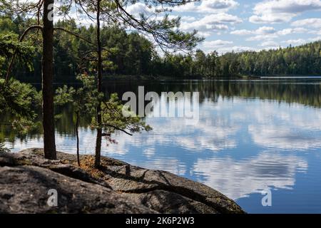 Panorama finlandese sul lago d'estate con la riflessione sul lago e le nuvole nel cielo. Parco Nazionale di Repovesi a Kouvola Foto Stock