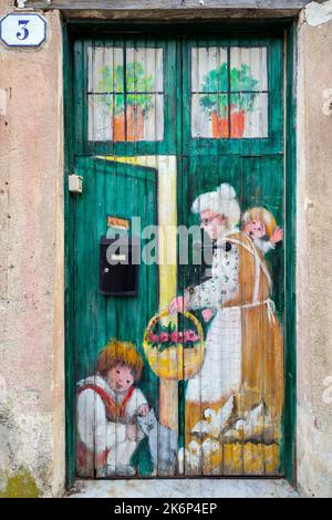 Un dipinto della porta che mostra temi della vita quotidiana della gente del posto, dell'artista Inelda Bassanello, nei pressi del Santuario di Savona. Liguria, Italia. Foto Stock