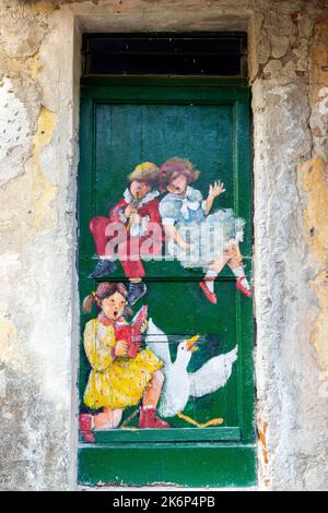 Un dipinto della porta che mostra temi della vita quotidiana della gente del posto, dell'artista Inelda Bassanello, nei pressi del Santuario di Savona. Liguria, Italia. Foto Stock