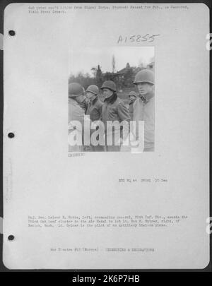 Generale maggiore Leland S. Hobbs, a sinistra, generale comandante 30th INF. Div., premia il cluster di foglie di quercia 3rd alla Medaglia d'aria a 1st Lt. Bob M. Spicer, a destra, di Renton, Washington. Spicer è il pilota di un aereo di collegamento artiglieria. Foto Stock