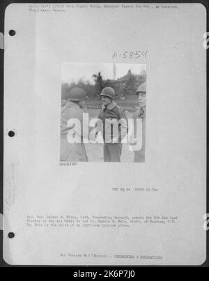 Il generale maggiore Leland S. Hobbs, a sinistra, generale comandante, premia il gruppo di foglie di quercia del 5th alla medaglia aerea al 1st Lt. Harold W. Hale, a destra, di Amburgo, N.Y. Hale è il pilota di un aereo di collegamento artiglieria. Foto Stock