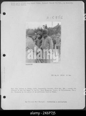 Generale maggiore Leland S. Hobbs, a sinistra, generale comandante 30th INF. Div., premia il Cluster alla Medaglia d'aria a 1st Ford Thompson, destra, di Tallahassee, Fla. Thompson è il pilota di un aereo di collegamento artiglieria. Foto Stock