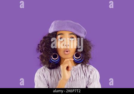 Giovane ragazza afroamericana con delizia e sorpresa guarda in su a copia spazio, WOW emozioni Foto Stock