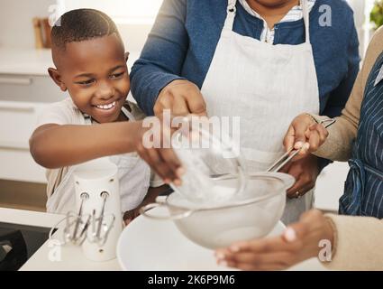 Tutto dentro là. una nonna che cuoce con i suoi due nipoti a casa. Foto Stock