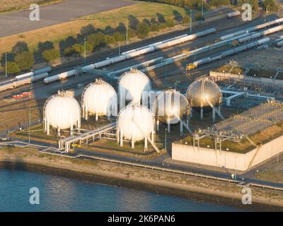 Contenitore di riserva serbatoio di petrolio a sfera per stoccaggio gas silo. In un grande porto commerciale industriale. Energia e prodotti liquidi per Foto Stock